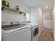 Well-lit laundry room equipped with modern washer and dryer units and ample storage space at 2230 S Platte River Rd, Sedalia, CO 80135