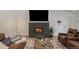 Cozy living room featuring a fireplace with modern TV, a leather couch, and a decorative rug at 2230 S Platte River Rd, Sedalia, CO 80135