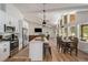 Open-concept kitchen, dining, and living space with island, stainless appliances, and natural lighting at 2230 S Platte River Rd, Sedalia, CO 80135