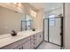 Bathroom featuring double sink vanity, large mirror, and modern shower stall at 9627 Browns Peak Cir, Littleton, CO 80125
