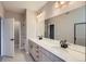 Bathroom featuring double sink vanity, large mirror, and modern lighting fixtures at 9627 Browns Peak Cir, Littleton, CO 80125