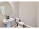 Powder room features a round mirror over a pedestal sink and a modern toilet at 9627 Browns Peak Cir, Littleton, CO 80125
