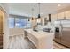 Bright kitchen boasts stainless appliances, island with sink, and stylish pendant lighting at 9627 Browns Peak Cir, Littleton, CO 80125