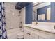 Well-lit bathroom featuring modern fixtures, a shower-tub combination, and white marble tiling at 1085 N Lafayette St # 704, Denver, CO 80218