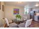 Charming dining area with modern art, comfortable chairs, and a view into updated kitchen at 1085 N Lafayette St # 704, Denver, CO 80218
