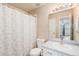 Bathroom with a shower featuring a white curtain, toilet, sink and a large mirror at 13421 Humboldt Way, Thornton, CO 80241