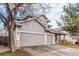 Two-story home featuring a three-car garage, gray siding and mature landscaping at 13421 Humboldt Way, Thornton, CO 80241