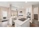 Well-lit kitchen with stainless appliances, quartz countertops, island with cooktop, and view to the living area at 13421 Humboldt Way, Thornton, CO 80241