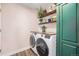 Practical laundry room equipped with modern appliances and shelving for storage at 13421 Humboldt Way, Thornton, CO 80241
