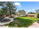 Spacious backyard with lush green lawn, mature tree and patio area perfect for outdoor entertaining at 5338 Granby St, Denver, CO 80239