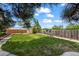 Large grassy backyard featuring a wood fence, mature trees, fountain, and storage shed at 5338 Granby St, Denver, CO 80239