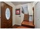 Warm entryway featuring hardwood floors, staircase, and decorative front door at 5338 Granby St, Denver, CO 80239