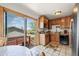 Functional kitchen with wood cabinets, tile floors, and sliding door to the deck at 5338 Granby St, Denver, CO 80239