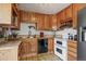 Efficient kitchen featuring oak cabinets, modern appliances, and tile flooring at 5338 Granby St, Denver, CO 80239