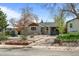 Charming single-story home featuring a cozy front porch and landscaped yard with rock features and lovely mature trees at 3368 S Corona St, Englewood, CO 80113