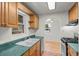 Kitchen with ample counter space, tiled floors, wood cabinets, and a view into the dining area at 3368 S Corona St, Englewood, CO 80113