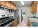 Efficient kitchen layout with modern appliances, wood cabinets, and direct access to laundry area at 3368 S Corona St, Englewood, CO 80113