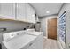 Functional laundry room includes washer, dryer, storage cabinets, and access door at 7902 Meade St # A10, Westminster, CO 80030