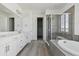 Bright bathroom features double sink vanity, a glass enclosed shower, and a tub at 25204 E Warren Pl, Aurora, CO 80018