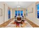 Bright dining room with large windows, chandelier lighting, glass table, and sliding doors at 2775 Morningbird Ln, Castle Rock, CO 80109