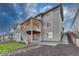 Two-story gray home featuring a walkout basement, covered patio, and landscaped backyard at 2775 Morningbird Ln, Castle Rock, CO 80109
