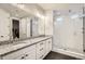 Bathroom with dual sink vanity, granite countertops, and walk-in shower with glass door at 1403 Hart Ln, Elizabeth, CO 80107