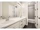 This modern bathroom features double sinks, white cabinetry, and a shower/tub combination at 1403 Hart Ln, Elizabeth, CO 80107