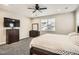 Cozy bedroom featuring dark wood furniture, gray carpet, and a large window at 1403 Hart Ln, Elizabeth, CO 80107