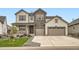 Charming two-story home features a stone facade and a spacious three-car garage with a landscaped front yard at 1403 Hart Ln, Elizabeth, CO 80107