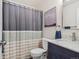 Charming bathroom with blue vanity, marble countertop, updated fixtures and a shower with curtain at 10657 Cherrybrook Cir, Highlands Ranch, CO 80126