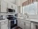 Updated kitchen featuring stainless steel appliances, white cabinets, and quartz countertops at 10657 Cherrybrook Cir, Highlands Ranch, CO 80126