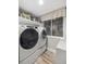 Bright laundry room with a window, modern washer and dryer, and ample storage space at 10657 Cherrybrook Cir, Highlands Ranch, CO 80126