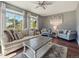 Cozy living room featuring large windows, neutral furniture, and a ceiling fan at 10657 Cherrybrook Cir, Highlands Ranch, CO 80126