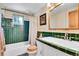 Retro bathroom featuring emerald green tiling and a wood trimmed medicine cabinet at 29551 Dorothy Rd, Evergreen, CO 80439