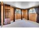 Spacious bedroom with wood paneling, neutral carpet, built in bookcase, and ample natural light at 29551 Dorothy Rd, Evergreen, CO 80439