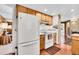 Kitchen with wooden cabinets, white appliances, and a view into a well lit living area at 29551 Dorothy Rd, Evergreen, CO 80439