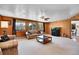 Open living room with hardwood trim, cozy seating, a large TV, and neutral carpet at 29551 Dorothy Rd, Evergreen, CO 80439