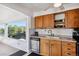 Efficient kitchen featuring wooden cabinets, a stainless steel dishwasher, ample counter space, and bright natural light at 2141 W Gill Pl, Denver, CO 80223