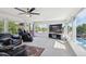 Spacious living room filled with natural light, featuring comfortable seating, a ceiling fan, and large windows with neighborhood views at 2141 W Gill Pl, Denver, CO 80223