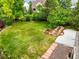 Aerial view of backyard with a large grass area, landscaped garden, and stone paver patio at 6364 S Walden Ct, Aurora, CO 80016