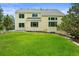Expansive backyard with a lush lawn and mature trees surrounding the yellow two-story home at 6364 S Walden Ct, Aurora, CO 80016
