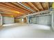 Unfinished basement featuring concrete walls, painted floor, and an exposed wood beam ceiling at 6364 S Walden Ct, Aurora, CO 80016