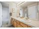 Bathroom featuring double sinks and warm wood cabinets and hardware at 6364 S Walden Ct, Aurora, CO 80016