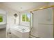 Bright bathroom features a soaking tub, separate shower, and a large window with tree views at 6364 S Walden Ct, Aurora, CO 80016