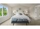 Bright bedroom featuring a large window, carpeted floor, and stylish decor above the bed at 6364 S Walden Ct, Aurora, CO 80016