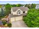 Two-story home boasts a three-car garage and bay window, nestled among lush green trees and landscaped yard at 6364 S Walden Ct, Aurora, CO 80016