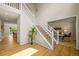 Bright foyer with hardwood floors, a staircase, and views into the living room and dining area at 6364 S Walden Ct, Aurora, CO 80016