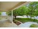 Covered front porch with white railings, offering a serene view of the landscaped yard and mature trees at 6364 S Walden Ct, Aurora, CO 80016