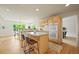 Bright kitchen featuring wood floors, island with bar seating, and double oven at 6364 S Walden Ct, Aurora, CO 80016
