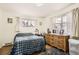 Bright bedroom featuring hardwood floors, a checkered comforter, and plenty of natural light at 4585 Garrison St, Wheat Ridge, CO 80033